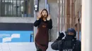 Salah seorang sandera wanita lari dari Kafe Lindt, Martin Place, Sydney, ke arah petugas polisi bersenjata, Senin (15/12/2014). (REUTERS/Jason Reed)