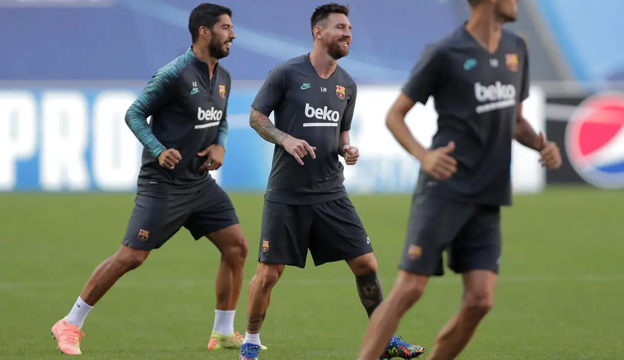 Penyerang Barcelona, Lionel Messi dan Luis Suarez melakukan pemanasan selama sesi latihan di stadion Da Luz, Lisbon, Portugal (13/8/2020). Barcelona akan bertanding melawan Bayern Munchen pada perempat final Liga Champions di Estadio da Luz.  (Rafael Marchante/Pool via AP)
