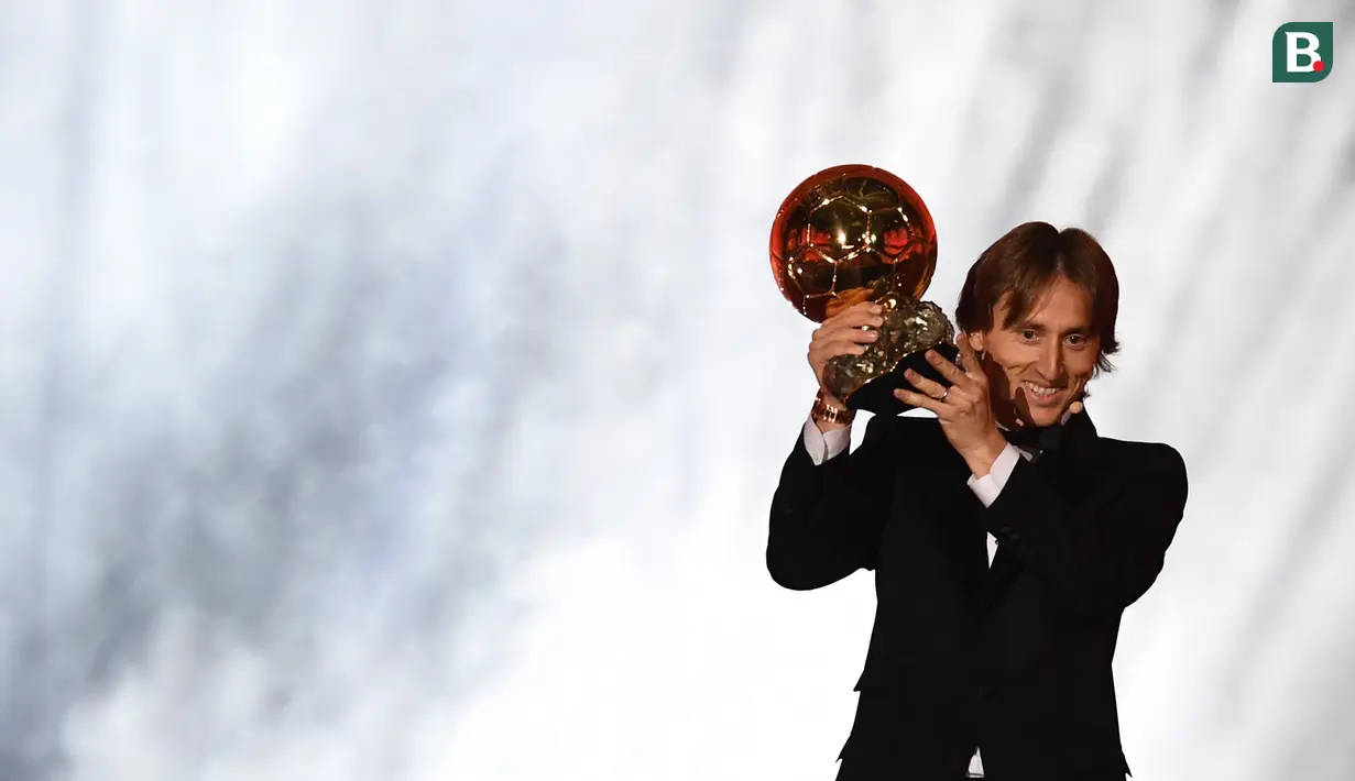 Gelandang Real Madrid asal Kroasia, Luka Modric, menunjukan trofi saat malam penghargaan Ballon d'Or di Paris, Senin (3/12). Dirinya berhasil meraih gelar Ballon d'Or. (AFP/Franck Fife)