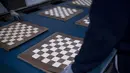 Seorang karyawan Rechapados Ferrer membuat papan catur di La Garriga dekat Barcelona (5/3/2021). Penjualan pembuat papan catur Spanyol itu melonjak sejak ditampilkan di serial Netflix terkenal "The Queen's Gambit". (AFP Photo/Josep Lago)