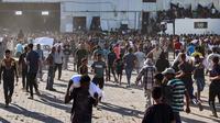 Warga Palestina yang kelaparan mengangkut kantong-kantong bantuan makanan dari gudang Program Pangan Dunia (WFP) di Deir al-Balah, Gaza.&nbsp;(Dok. Eyad Baba/AFP)