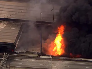 Kebakaran hebat yang terjadi di kolong jembatan layang Interstate-85 di Atlanta, Negara Bagian Georgia, Amerika Serikat (AS), menyebabkan ruas jalan tol itu runtuh, Kamis (30/3). Jembatan layang itu dikenal sebagai jalur tersibuk di AS. (WSB-TV via AP)