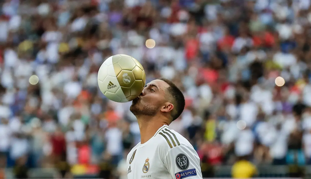 Pemain baru Real Madrid, Eden Hazard mencium bola saat diperkenalkan di stadion Santiago Bernabeu di Madrid, Spanyol (13/6/2019). Real Madrid mengumumkan telahresmi membeli pemain asal Belgia tersebut dari klub Inggris, Chelsea. (AP Photo/Manu Fernandez)