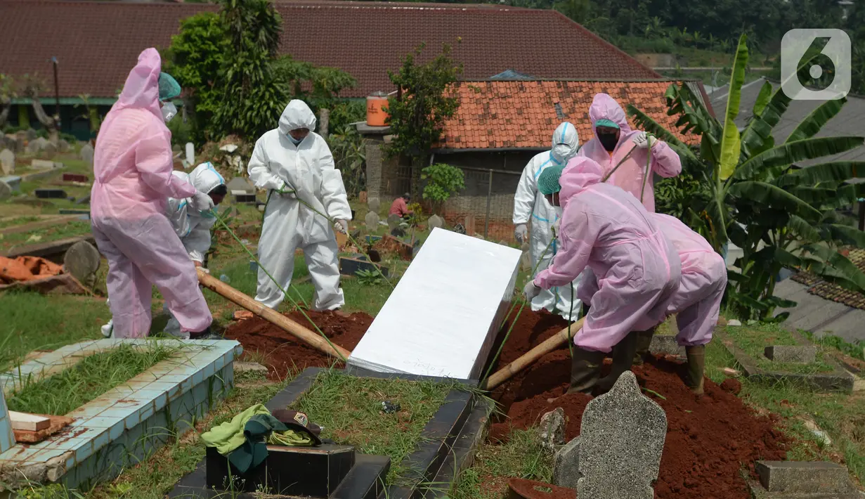 Petugas pemulasaraan jenazah Covid-19 memakamkan jenazah yang meninggal ketika menjalani isolasi mandiri di Kampung Gedong, Jakarta, Sabtu (10/7/2021). Proses pemulasaran jenazah dilakukan sesuai prokes Covid-19 dikarenakan hasil test swab korban positif. (merdeka.com/Imam Buhori)