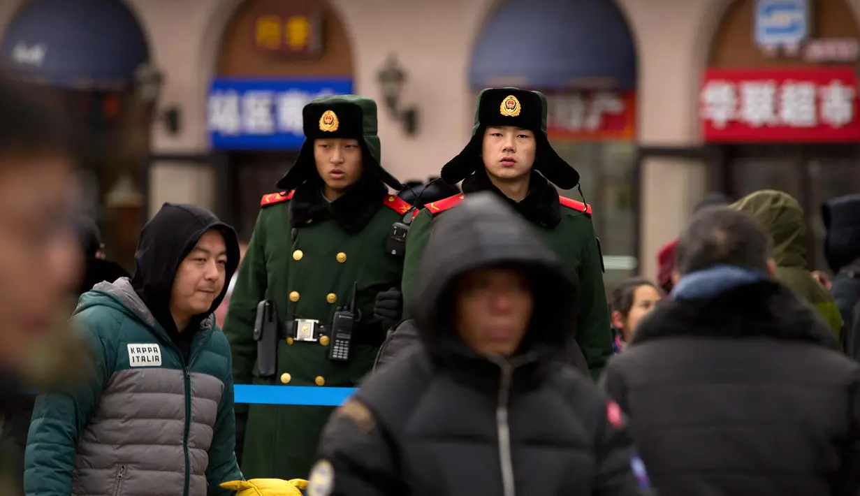 Polisi paramiliter China berjaga di luar Stasiun Kereta Api Beijing, China (9/2). Sambut perayaan Imlek 2018, Jutaan warga China mulai memenuhi stasiun, bandara dan jalan yang diperkirakan akan dimulai akhir pekan ini. (AP Photo / Mark Schiefelbein)