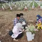 Warga berdoa di depan pusara keluarganya saat ziarah kubur di TPU Srengseng Sawah 2, Jagakarsa, Jakarta Selatan, Senin (17/5/2021). Hari ini seluruh TPU di wilayah DKI dibuka untuk umum dengan menerapkan protokol kesehatan seperti pembatasan pengunjung dan waktu berziarah. (merdeka.com/Arie Basuki)