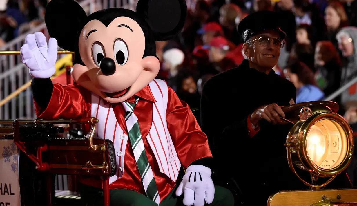 Karakter Mickey Mouse menaiki mobil saat mengikuti Parade Natal Hollywood ke-85 di Los Angeles, California, AS (27/11). Parade ini dirayakan tiap tahunnya untuk menyambut datangnya Hari Raya Natal. (Reuters/Phil McCarten)
