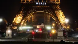 Kata "Merci atau terima kasih terpampang di Menara Eiffel, Paris, Jumat (27/3/2020). Menara Eiffel menyala untuk menampilkan pesan dukungan dan terima kasih kepada tenaga kesehatan di Prancis yang berada di garda depan memerangi pandemi COVID-19.  (AP/Thibault Camus)