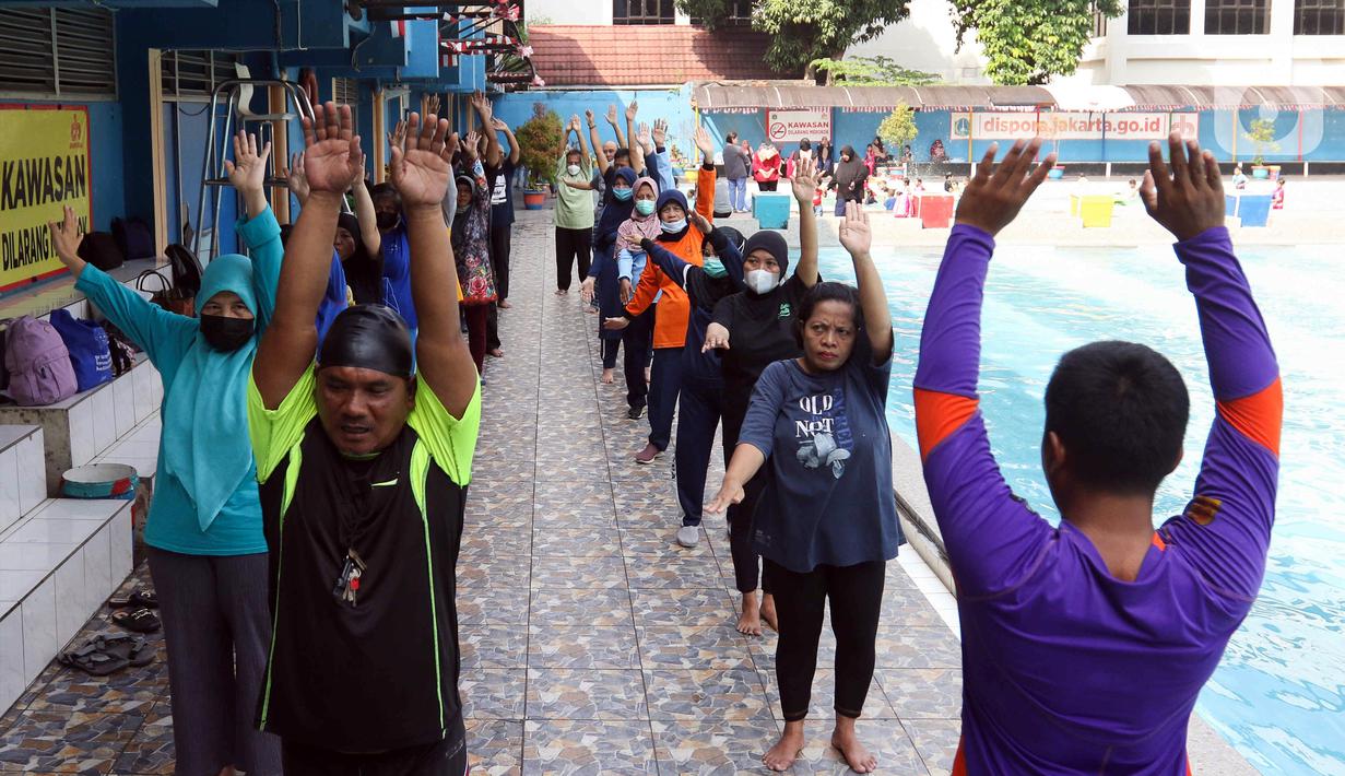 Sejumlah peserta melakukan pemanasan saat berlatih berenang pada kegiatan Gerakan Prolanis Total (Gelato) di Gelanggang Remaja KONI, Gambir, Jakarta, Kamis (11/8/2022). Puskesmas Kecamatan Gambir mengadakan kegiatan Gelato berupa pelatihan berenang kepada peserta lansia penderita penyakit kronis untuk mencegah penyakit tersebut tambah parah. (Liputan6.com/Herman Zakharia)