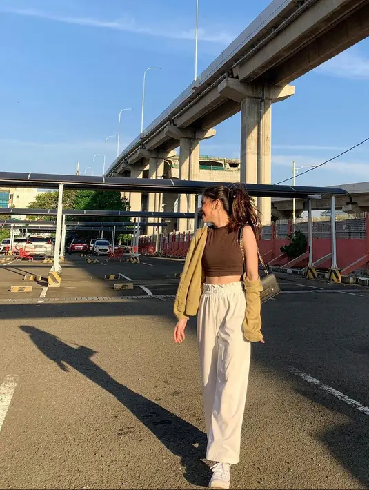 <p>Knit outer berwarna khaki, inner berwarna coklat dan celana putih adalah outfit ternyaman saat sedang di Bandara.&nbsp;(instagram/bellagap)</p>