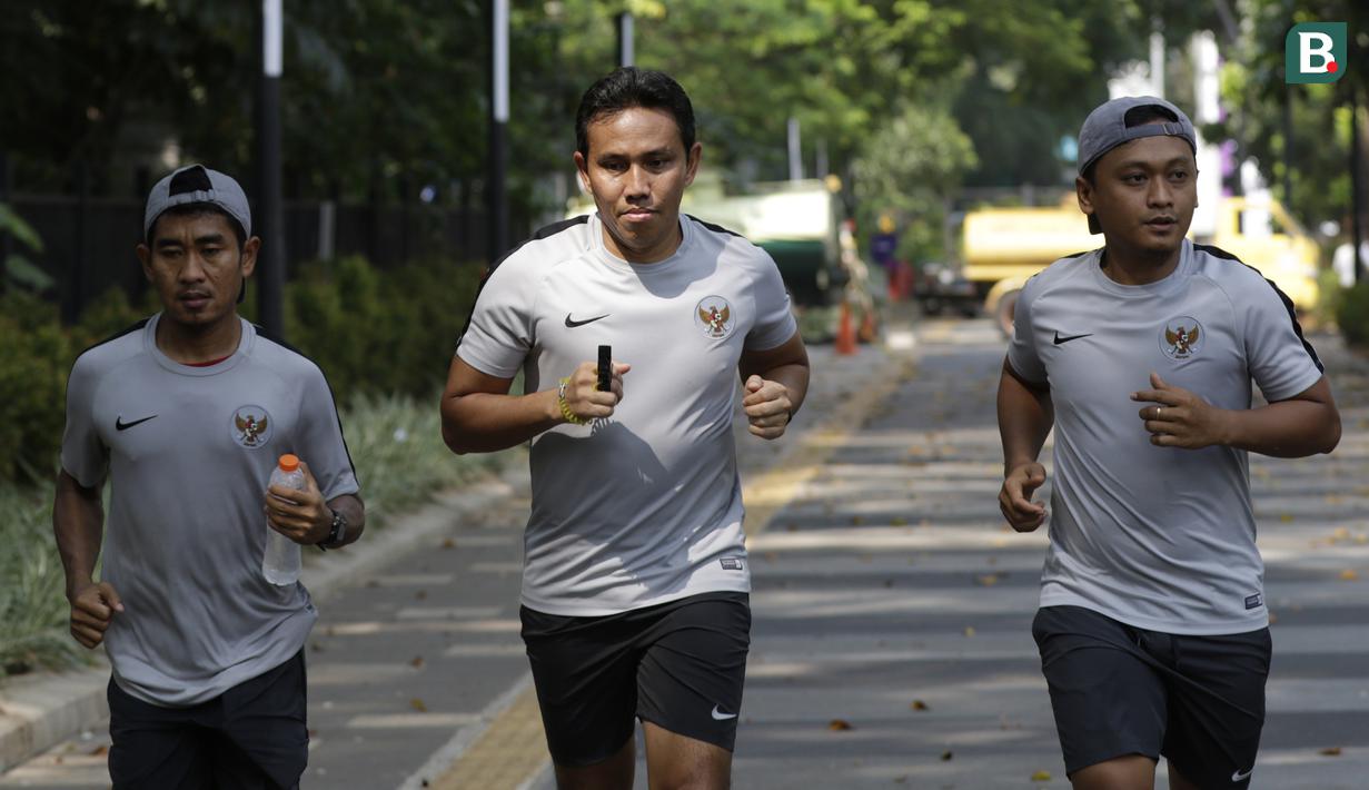 Pelatih Timnas Indonesia, Bima Sakti, bersama staf pelatihnya jogging menuju penginapan usai latihan di Stadion Madya Senayan, Jakarta, Rabu (21/11). Kebiasaan ini sering dilakukan sejak era Luis Milla. (Bola.com/M. Iqbal Ichsan)