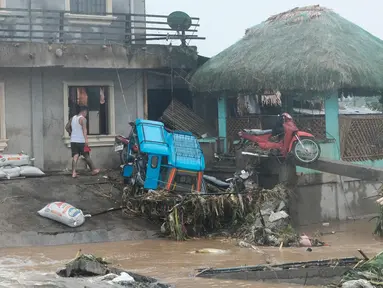 Seorang pria berjalan melewati kerusakan yang disebabkan oleh banjir bandang pada Kamis 24 Oktober 2024 di kota Libon, provinsi Albay, Filipina. (AP Photo/John Michael Magdasoc)