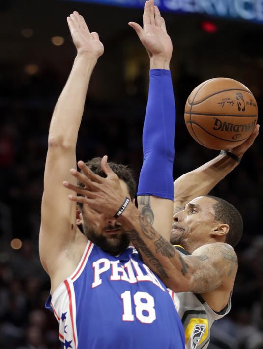 Aksi pemain Cleveland Cavaliers, George Hill (kanan) melakukan dunk saat diadang pemain Philadelphia 76ers, Marco Belinelli #18 pada laga NBA basketball game di Quicken Loans Arena, Cleveland,  (1/2/2018).  Cavs kalah 97-108. (AP /Tony Dejak)
