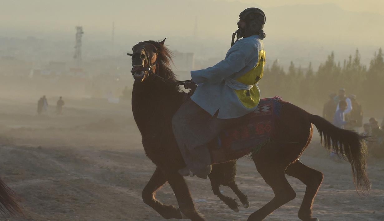 Penunggang kuda Afghanistan bersaing memperebutkan bangkai hewan dalam pertandingan Buzkashi di Herat, Afghanistan (4/2/2022). Buzkashi merupakan tradisi yang dilakukan oleh warga Afghanistan yang setiap pesertanya harus menunggang kuda. (AFP/Wakil Kohsar)