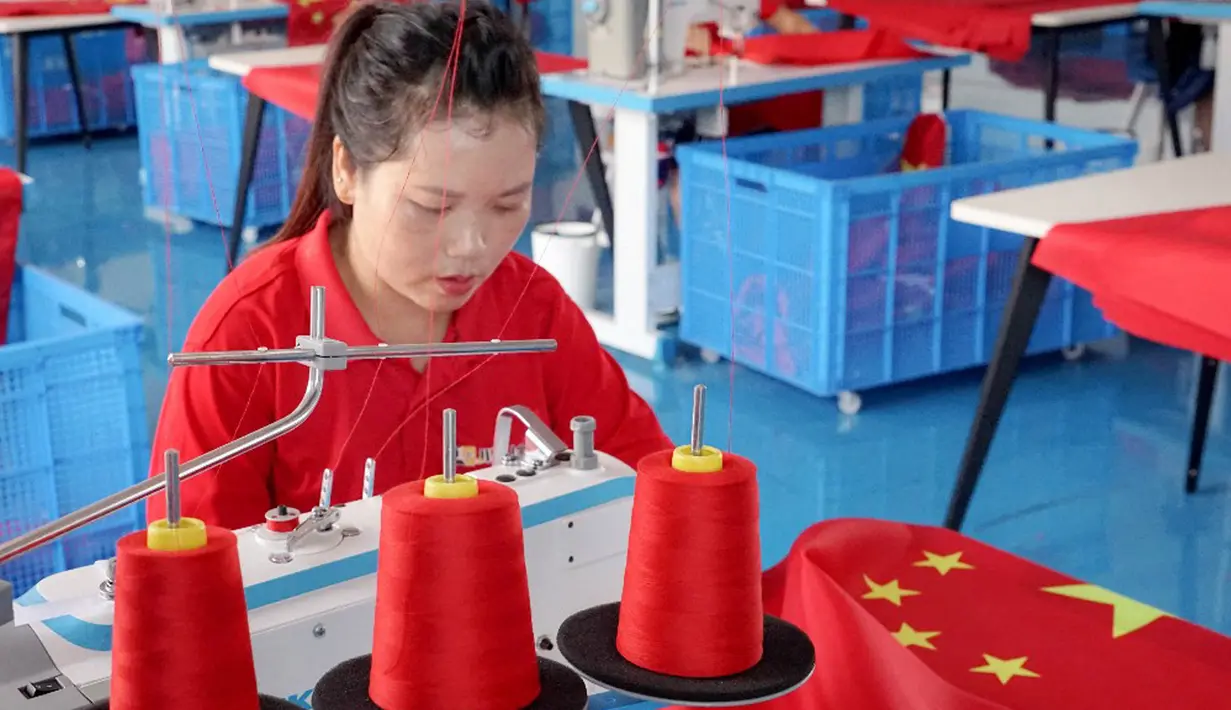Pekerja membuat bendera nasional di sebuah pabrik menjelang Hari Nasional di Wuyi, Provinsi Zhejiang, China, 28 September 2021. Hari Nasional adalah sebuah hari libur nasional di China untuk merayakan hari kebangsaan mereka dan diperingati pada tanggal 1 Oktober setiap tahun. (STR/AFP)