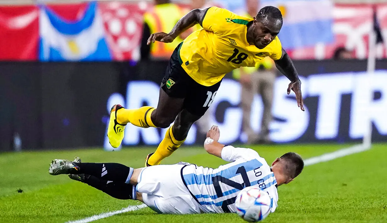 Pemain Argentina Giovani Lo Celso (bawah) berebut bola dengan pemain Jamaika Michail Antonio pada pertandingan persahabatan di Harrison, New Jersey, Amerika Serikat, 27 September 2022. Argentina menang 3-0 dengan Messi mencetak dua gol. (AP Photo/Eduardo Munoz Alvarez)