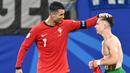 Penyerang Portugal #07 Cristiano Ronaldo mengucapkan selamat kepada #26 Francisco Conceicao setelah ia mencetak gol kedua timnya ke gawang Republik Ceko pada laga grup F Euro 2024 di Red Bull Arena, Leipzig, Rabu (19/6/2024) dini hari WIB. (Christophe SIMON / AFP)