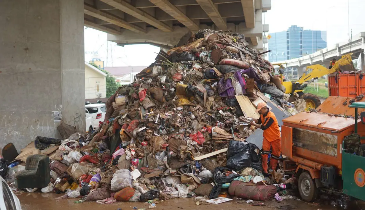 Petugas mengangkut sampah sisa banjir yang menumpuk di kawasan Cipinang Melayu, Jakarta, Senin (6/1/2020). Banjir yang menggenangi Jakarta dan sekitarnya sejak 1 Januari 2020 lalu menyisakan tumpukan sampah di sejumlah titik. (Liputan6.com/Immanuel Antonius)