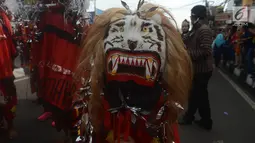 Peserta mengenakan kostum reog saat mengikuti karnval budaya untuk memeriahkan HUT ke-19 kota Depok di Sepanjang Jalan Margonda, Depok, Sabtu (28/4). (Merdeka.com/Imam Buhori)