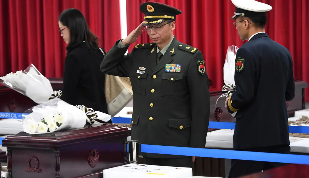 Perwira militer China memberi penghormatan di antara kerangka tentara seniornya pada upacara ritual di osuarium militer, Incheon, Seoul, Senin (26/3). Tulang belulang 20 tentara itu akan dibawa ke China untuk dimakamkan. (Jung Yeon-je/Pool Photo via AP)