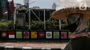 Warga melintasi mural sosialisasi bahaya COVID-19 di Jalan Sultan Iskandar Muda, Jakarta, Rabu (23/9/2020). PSBB pengetatan sepekan terakhir ini belum efektif menurunkan angka jumlah harian Covid-19 di DKI yang tercatat bertambah 1.122 kasus di ibu kota pada Selasa (22/9). (Liputan6.com/Johan Tallo)