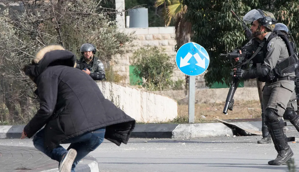 Seorang pria Palestina terjatuh usai ditembak dari jarak dekat oleh polisi Israel di dekat Ramallah, Tepi Barat, Jumat (15/12). Pemuda ini ditembak usai menikam tentara perbatasan Israel. (AFP Photo/Oren Ziv)