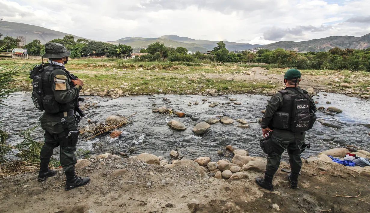 Petugas polisi Kolombia berjaga di "trochas" - jalur ilegal di perbatasan antara Kolombia dan Venezuela, dekat jembatan internasional Simon Bolivar, di Cucuta, Kolombia (14/10/2020). (AFP/Schneyder Mendoza)