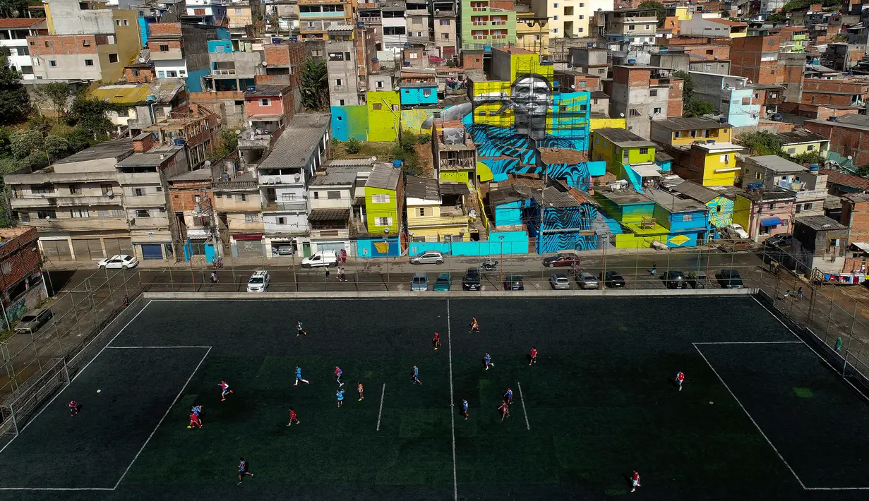 Pemandangan saat anak-anak bermain sepak bola di sebuah lapangan di Jardim Peri, Sao Paulo, Brasil, Minggu (20/5). Daerah ini merupakan tempat di mana pemain sepak bola profesional Gabriel Jesus tumbuh. (AP Photo/Andre Penner)
