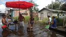 <p>Warga memasak di jalan yang dibanjiri oleh naiknya sungai Negro di Iranduba, negara bagian Amazonas, Brasil, Senin (23/5/2022). Wilayah Amazon sedang dilanda banjir dengan 35 kotamadya yang menghadapi salah satu banjir terburuk mereka dalam beberapa tahun dan permukaan air diperkirakan akan meningkat selama beberapa bulan mendatang. (AP Photo/Edmar Barros)</p>