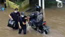 Warga berjalan menyusuri banjir yang menggenangi sebagian ruas Jalan Warung Buncit Raya, Jakarta, Sabtu (20/2/2021). Hujan yang mengguyur Jakarta sejak Jumat (19/2) membuat arus lalu lintas sejumlah jalan di Jakarta lumpuh akibat terendam banjir. (Liputan6.com/Helmi Fithriansyah)