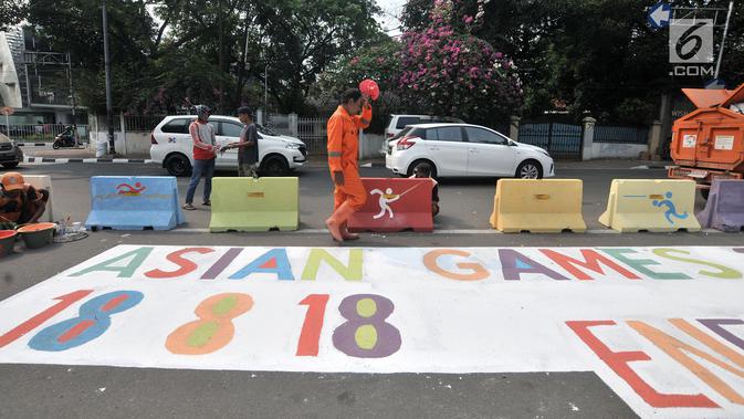 Pekerja dari PPSU Kelurahan Pegangsaan saat menyelesaikan pembuatan maskot dan logo Asian Games 2018 di Jalan Penataran atau Simpang Tugu Proklamasi, Jakarta, Rabu (25/7).  (Merdeka.com/Iqbal S. Nugroho)