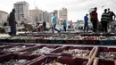 Hasil laut tangkapan nelayan diletakkan di area terbuka saat sejumlah pembeli melihat berbagai hasi laut di kawasan Gaza (23/5/2021). Pelelangan hasil laut di Gaza kembali bergeliat usai sejumlah kapal nelayan diizinkan kembali melaut pasca Israel-Hamas gencatan senjata. (AP Photo/John Minchillo)