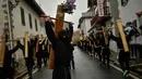 Sejumlah peninten bertopeng membawa salib saat ritual musim semi '' Romeria Cruceros de Arce '' di Spanyol utara (13/5). Mereka menggelar ritual ini untuk menghormati Santa Perawan. (AP / Alvaro Barrientos)