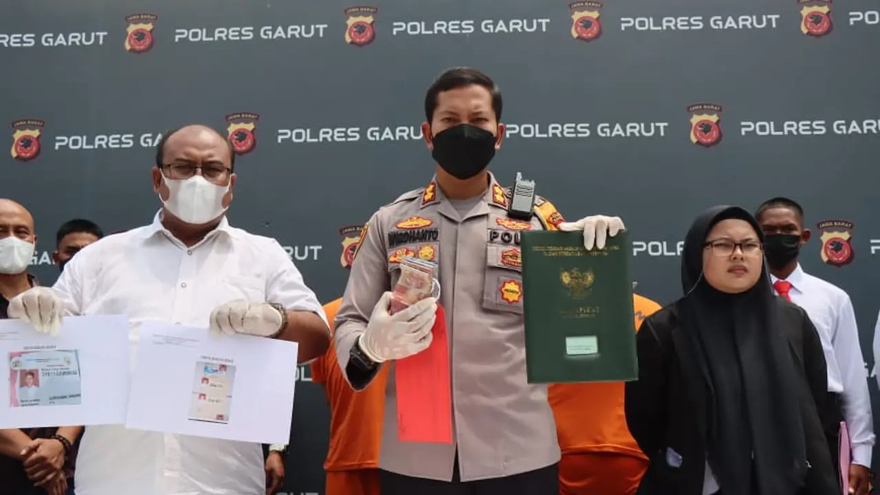 Kapolres Garut AKBP Wirdhanto Hadicaksono didampingi Kasatreskrim Garut AKP Dede Sopandi menunjukan barang bukti penipuan berkedok lulus tes AKpol Polri tanpa tes. (Liputan6.com/Jayadi Supriadin)