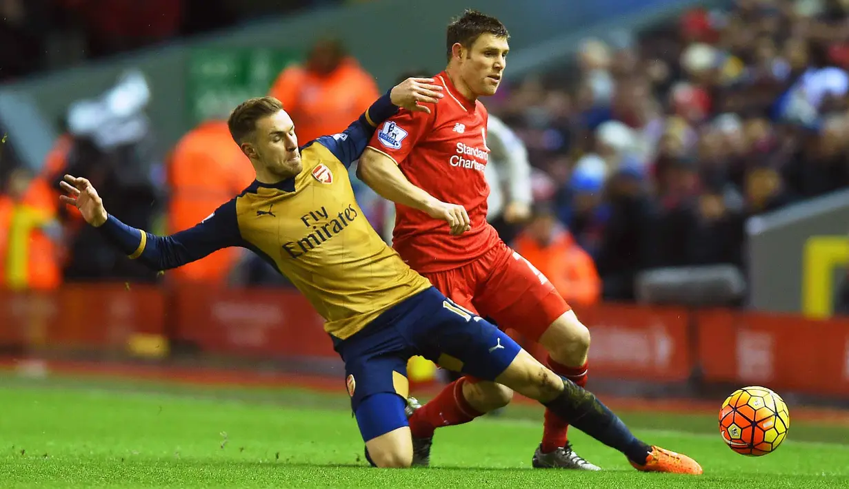 Pemain Liverpool, James Milner (kanan)  berebut bola dengan pemain  Arsenal, Aaron Ramsey (kiri) pada lanjutan Liga Premier Inggris di Stadion Anfield, Liverpool, Kamis (13/1/2016) dini hari.  (EPA/Peter Powell)
