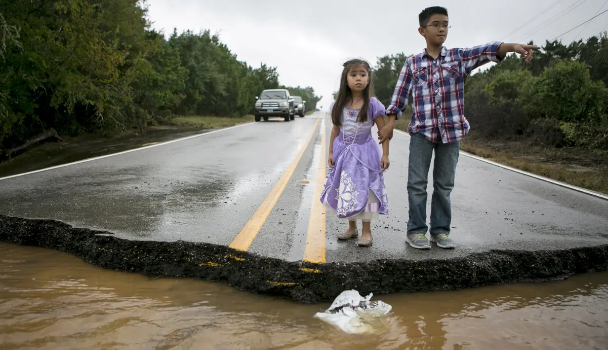 Duar Orang anak saat melihat jalanan yang rusak akibat Tornado yang menyaou bagian kota Texas, Amerika Serikat, Jumat (30/10/2015). Akibat peristiwa sudah lebih dari 20 orang tewas sejak Mei lalu. (REUTERS/Ilana Panich - Linsman)