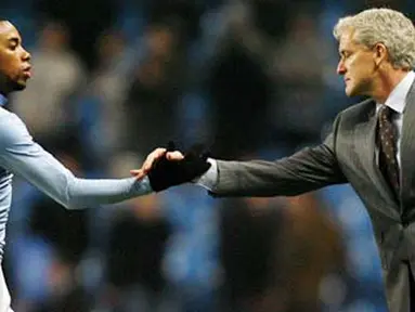 Manchester City&#039;s striker Robinho shakes hands with manager Mark Hughes after winning their Premier League football match against Newcastle at the City Of Manchester Stadium in Manchester on January 28, 2009. AFP PHOTO/Glyn Kirk