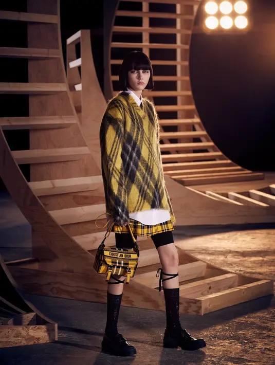 Busana yang ditonjolkan dalam koleksi ini adalah clueless style yang terlihat dalam busana motif plaid warna kuning dan pola warna hitam. (Dok/Dior).