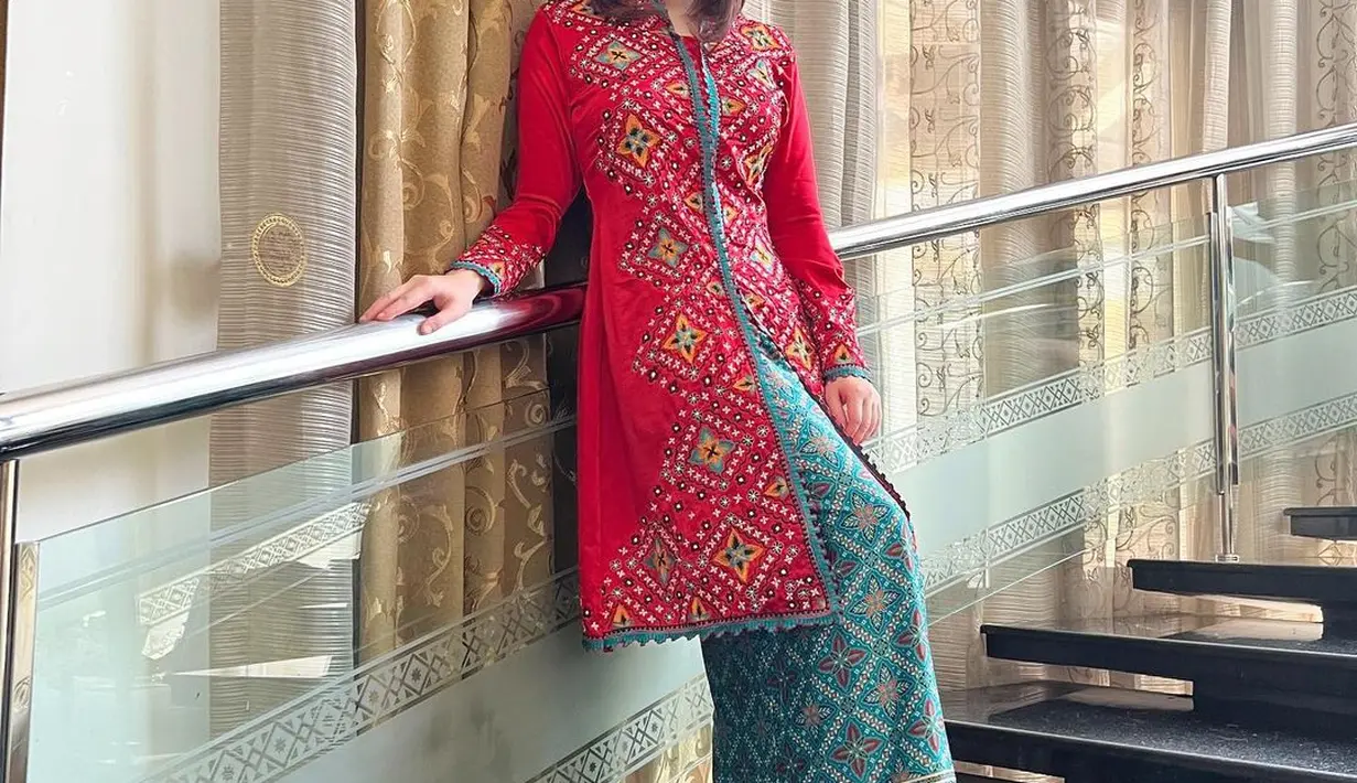 Di potret ini, Tina Toon kenakan kebaya panjang bordir dan rok batik dengan warna kontras [@tinatoon101]