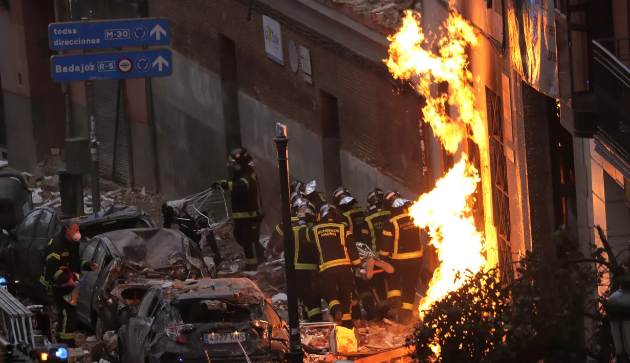 Petugas pemadam kebakaran membawa mayat di samping bangunan yang rusak di Jalan Toledo menyusul ledakan di pusat kota Madrid, Spanyol, Rabu (20/1/2021). Ledakan dahsyat yang disebabkan kebocoran gas telah menghancurkan bangunan di jantung ibu kota Spanyol, Madrid. (AP Photo/Manu Fernandez)