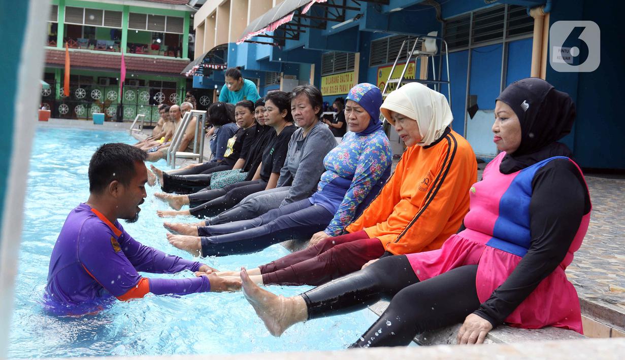 Sejumlah peserta melakukan pemanasan saat berlatih berenang pada kegiatan Gerakan Prolanis Total (Gelato) di Gelanggang Remaja KONI, Gambir, Jakarta, Kamis (11/8/2022). Puskesmas Kecamatan Gambir mengadakan kegiatan Gelato berupa pelatihan berenang kepada peserta lansia penderita penyakit kronis untuk mencegah penyakit tersebut tambah parah. (Liputan6.com/Herman Zakharia)