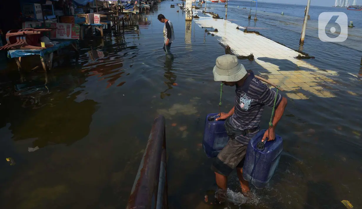 Akivitas warga saat terjadinya banjir rob di Pelabuhan Kali Adem, Muara Angke Jakarta, Rabu (5/1/2022). Menurut BMKG, adanya fase bulan baru yang bersamaan dengan masa Perigee (jarak terdekat bulan bumi) menyebabkan peningkatan signifikan ketinggian pasang air laut. (merdeka.com/Imam Buhori)