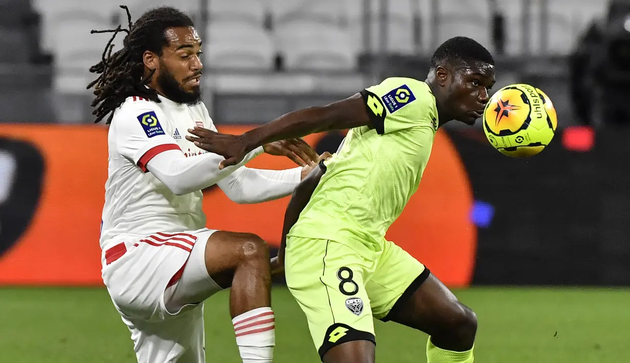 Bek Olympique Lyon, Jason Denayer, berebut bola dengan gelandang Dijon, Eric Junior Dina-Ebimbe, pada laga Ligue 1 di Stadion Groupama, Sabtu (29/8/2020) dini hari WIB. Lyon menang 4-1 atas Dijon. (AFP/Philippe Desmazes)