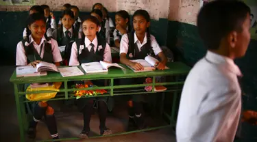 Mantan Dewi Nepal atau Kumari, Matina Shakya (tengah) duduk di kelas pada hari pertama sekolahnya di Kathmandu (9/10). Setelah pubertas Matina Shakya harus pensiun menjadi sosok dewi hidup yang disembah banyak orang di Nepal. (AFP Photo/Gopen Rai)