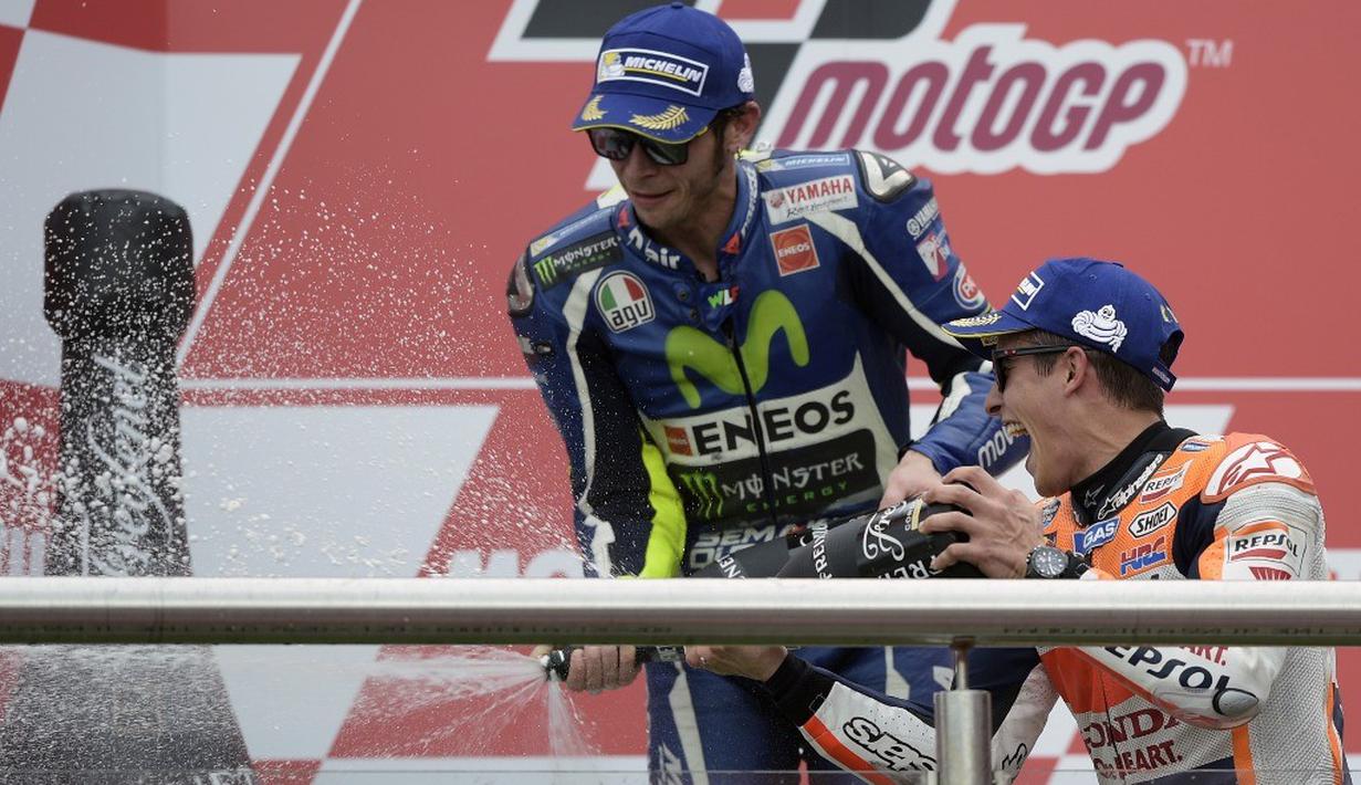 Marc Marquez dan Valentino Rossi saling semprot sampanye di podium juara MotoGP Argentina di Sirkuit Autodromo Termas de Rio Hondo, Senin (4/4/2016) dini hari WIB. (AFP/Juan Mabromata))
