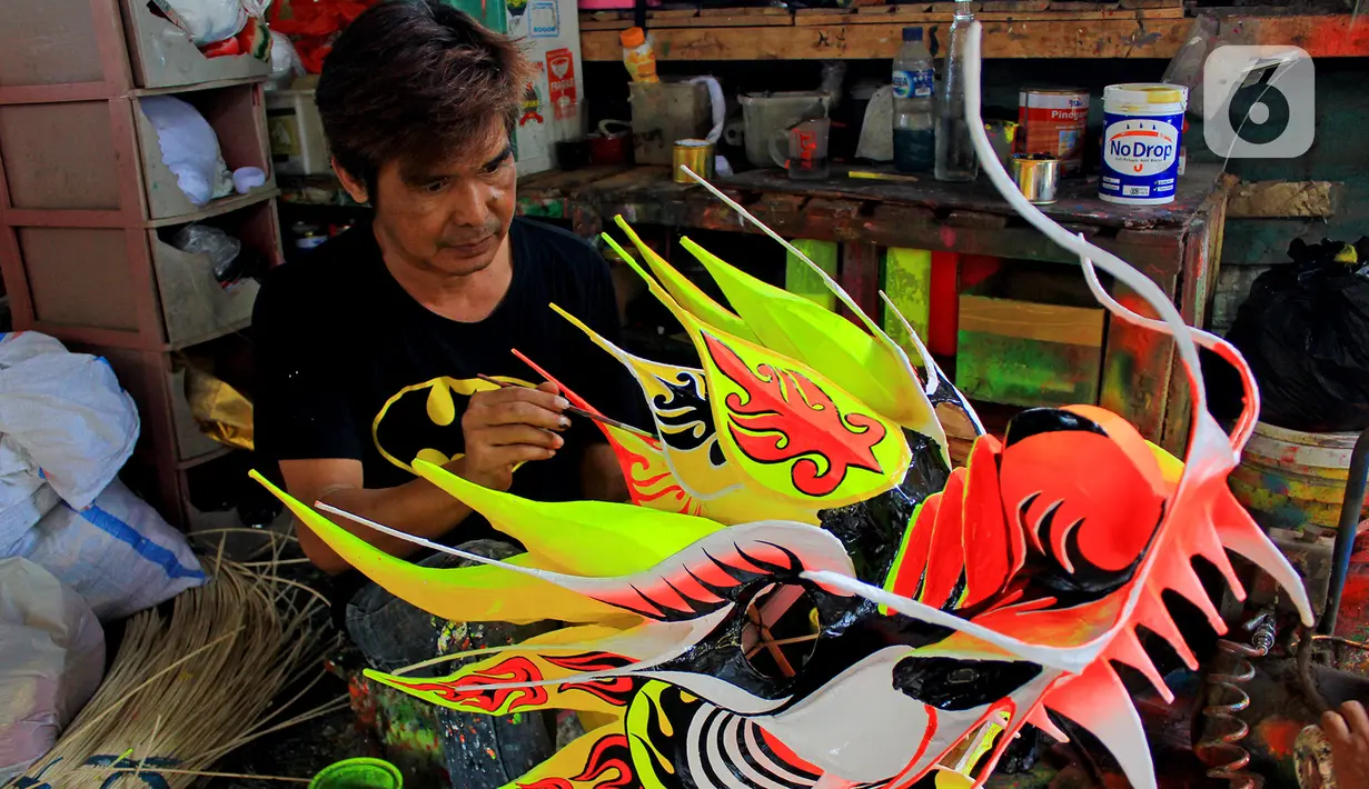 Pekerja sedang melakukan pelukisan kerangka liong Lily Hambali di Jalan Roda, Babakan Pasar, Bogor, Jawa Barat, Selasa (21/1/2020). Jelang hari raya Imlek pengrajin rumahan barongsai dan liong Lily Hambali ramai pemesanan. (merdeka.com/Magang/Muhammad Fayyadh)