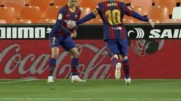 Penyerang Barcelona, Antoine Griezmann berselebrasi dengan rekannya Lionel Messi usai mencetak gol ke gawang Valencia pada pertandingan La Liga Spanyol di stadion Mestalla, Senin (3/5/2021). Barcelona menang tipis atas Valencia 3-2. (AP Photo/Alberto Saiz)