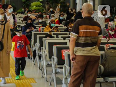 Calon penumpang membawa anaknya berjalan di Stasiun Senen, Jakarta, Sabtu (23/10/2021). PT Kereta Api Indonesia (Persero) kembali memperbolehkan anak-anak usia di bawah 12 tahun naik KA Jarak jauh mulai 22 Oktober 2021. (Liputan6.com/Faizal Fanani)
