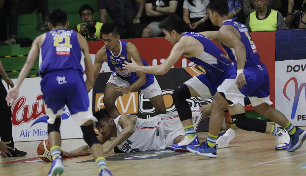 Pebasket NSH Jakarta, Tri Hartanto, terjatuh saat berebut bola dengan pemain Satria Muda pada laga semi final IBL 2019 di GMSB Kuningan, Jakarta, Minggu (10/3). Satria Muda menang 72-48 atas NSH Jakarta. (Bola.com/M Iqbal Ichsan)