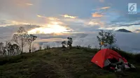 Tenda pendaki terlihat berada di Pos 2 Gunung Sumbing dengan latar belakang pemandangan Gunung Sindoro saat senja di Wonosobo, Jawa Tengah (3/4). Gunung ini memiliki pemandangan yang indah serta jalur terjal dan ekstrem dari basecamp hingga puncak Rajawali. (merdeka.com/Iqbal S. Nugroho)